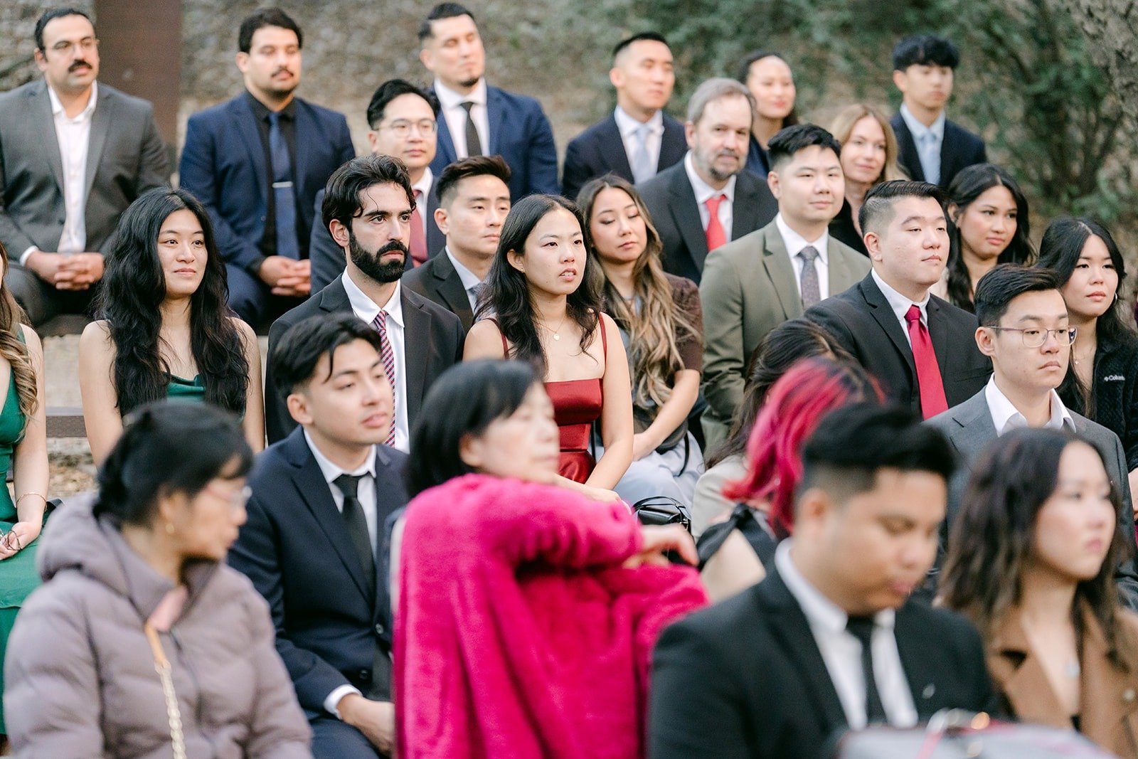 Guests on wooden benches watching the ceremony