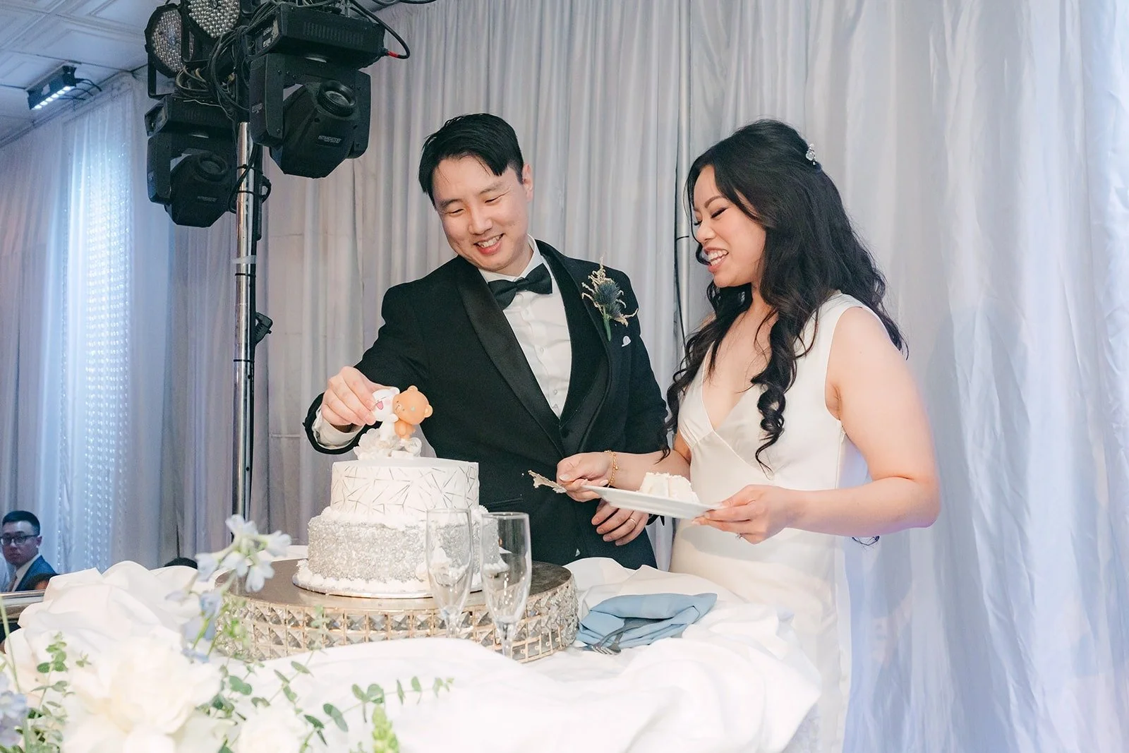 Emily and James laughing at the cake table