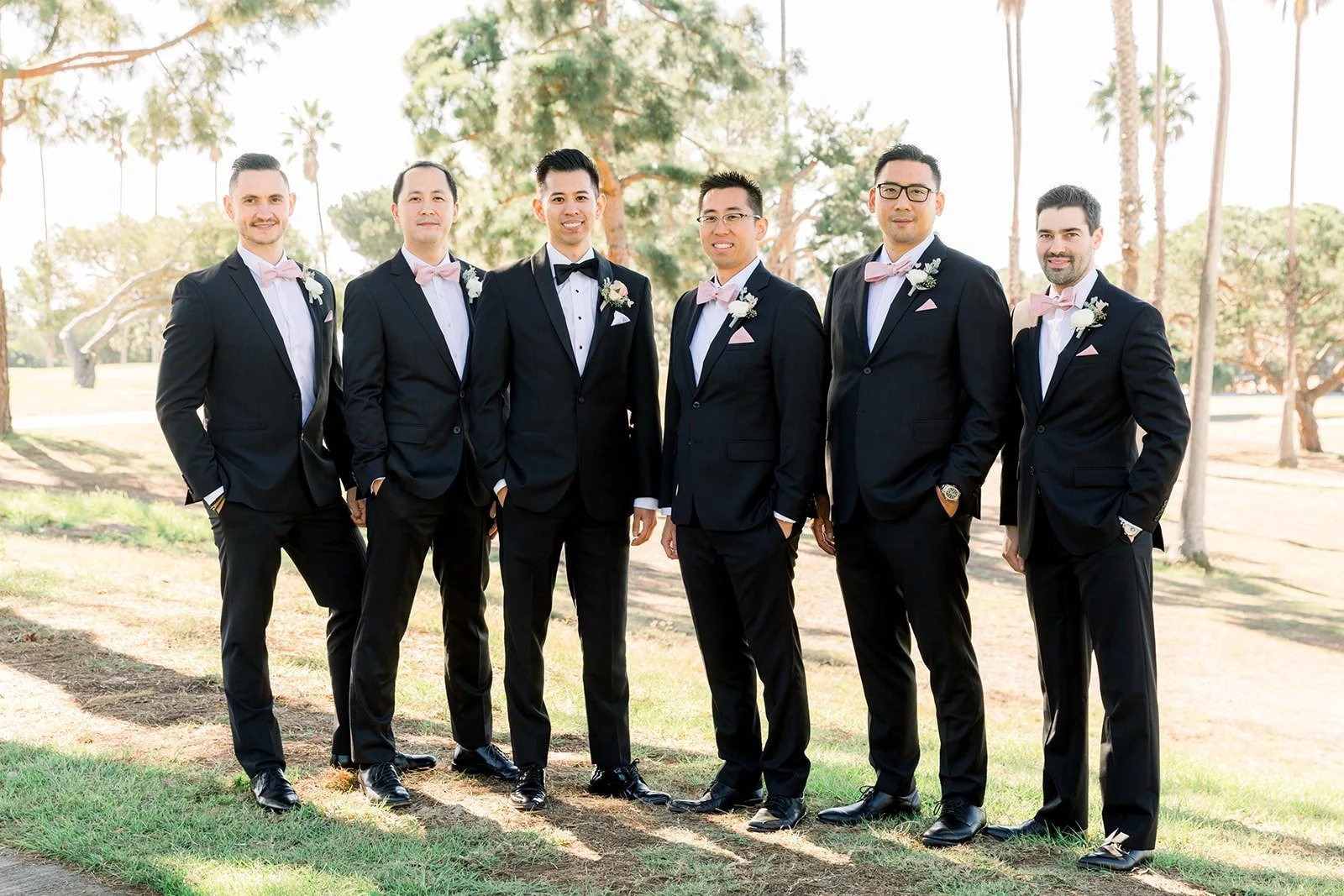 David and his groomsmen in black tuxedos on the lawn