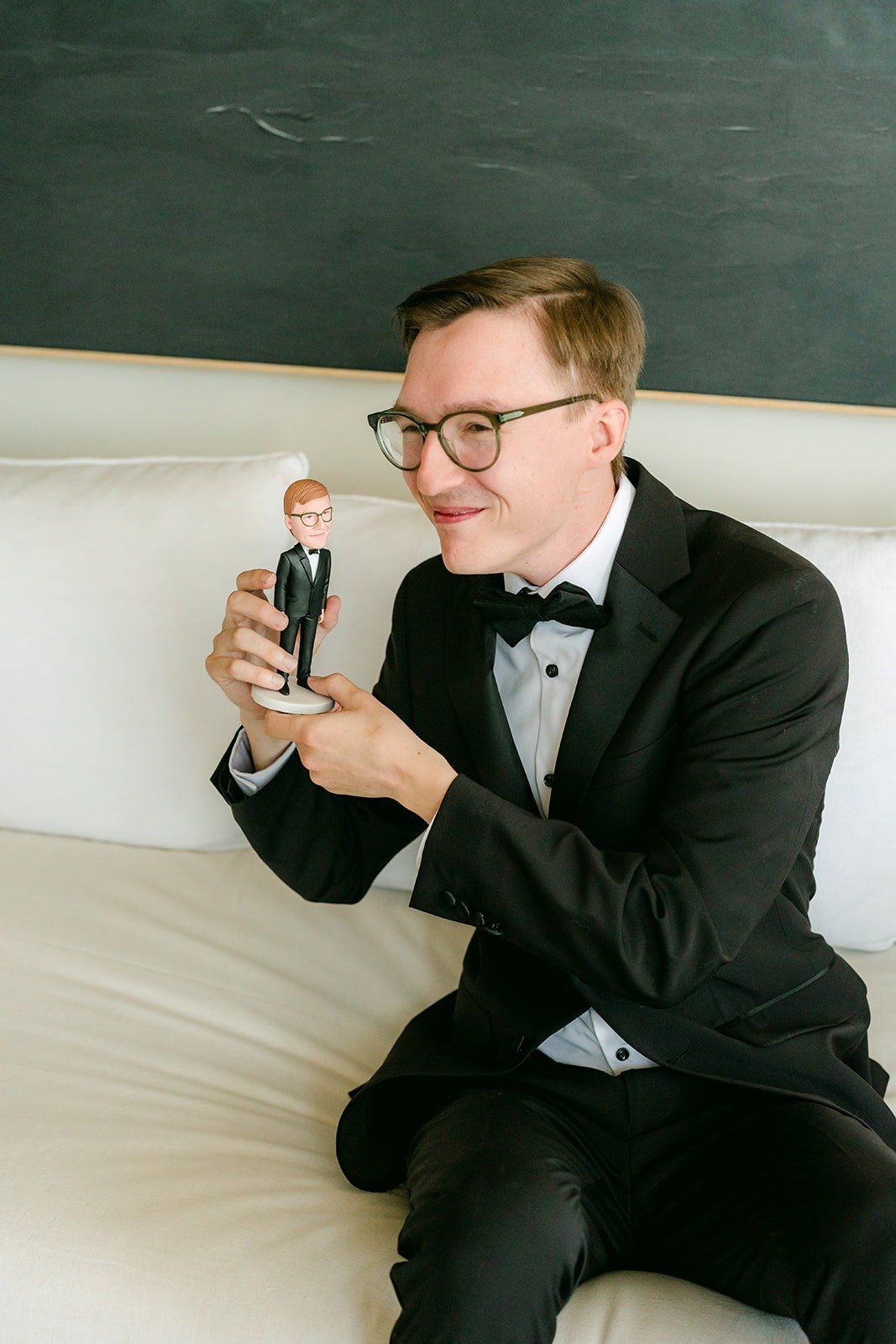 Nik showing off a little figurine while getting ready