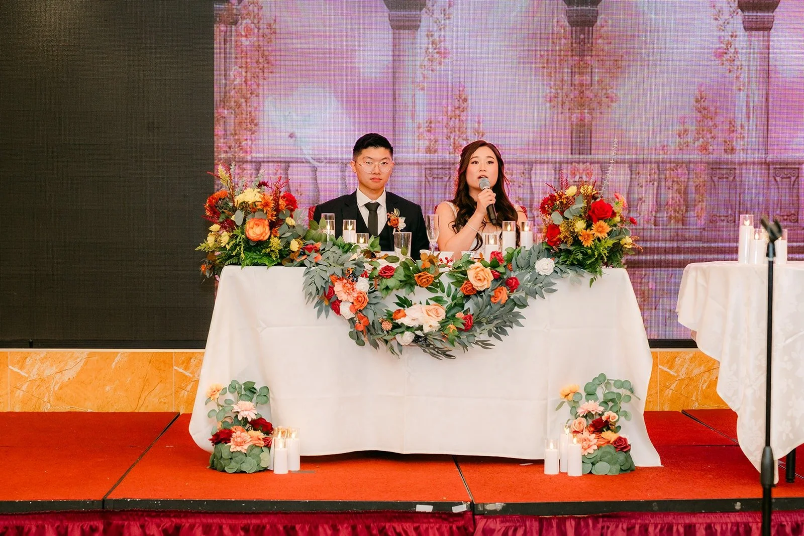 Shayna and Robert listen to the speeches at the sweetheart table