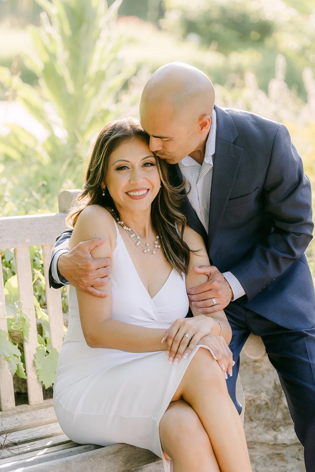Francesca laughs as Daniel holds her close on the gazebo bench.