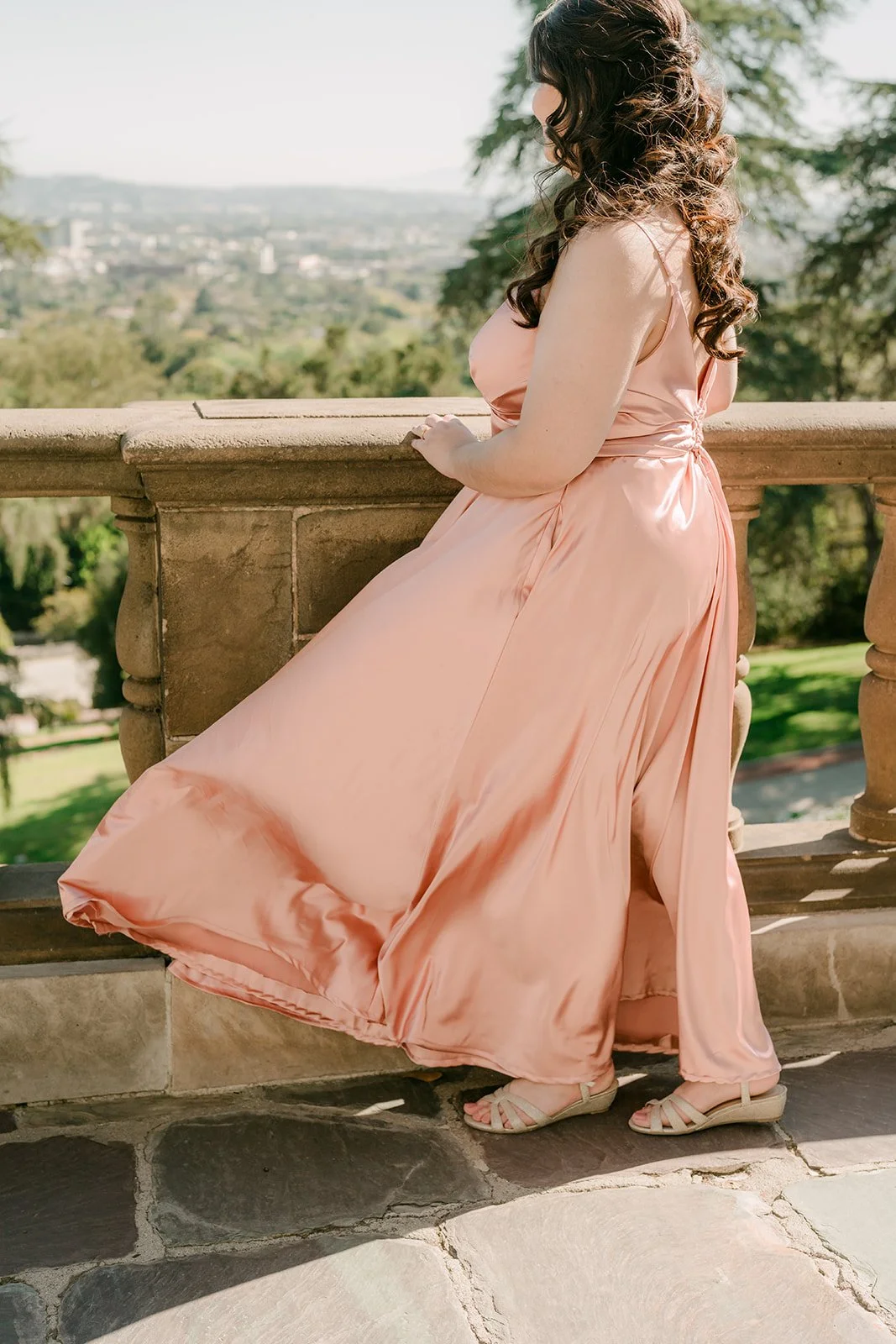 Saira at the balustrade overlooking the city as her gown catches the breeze.