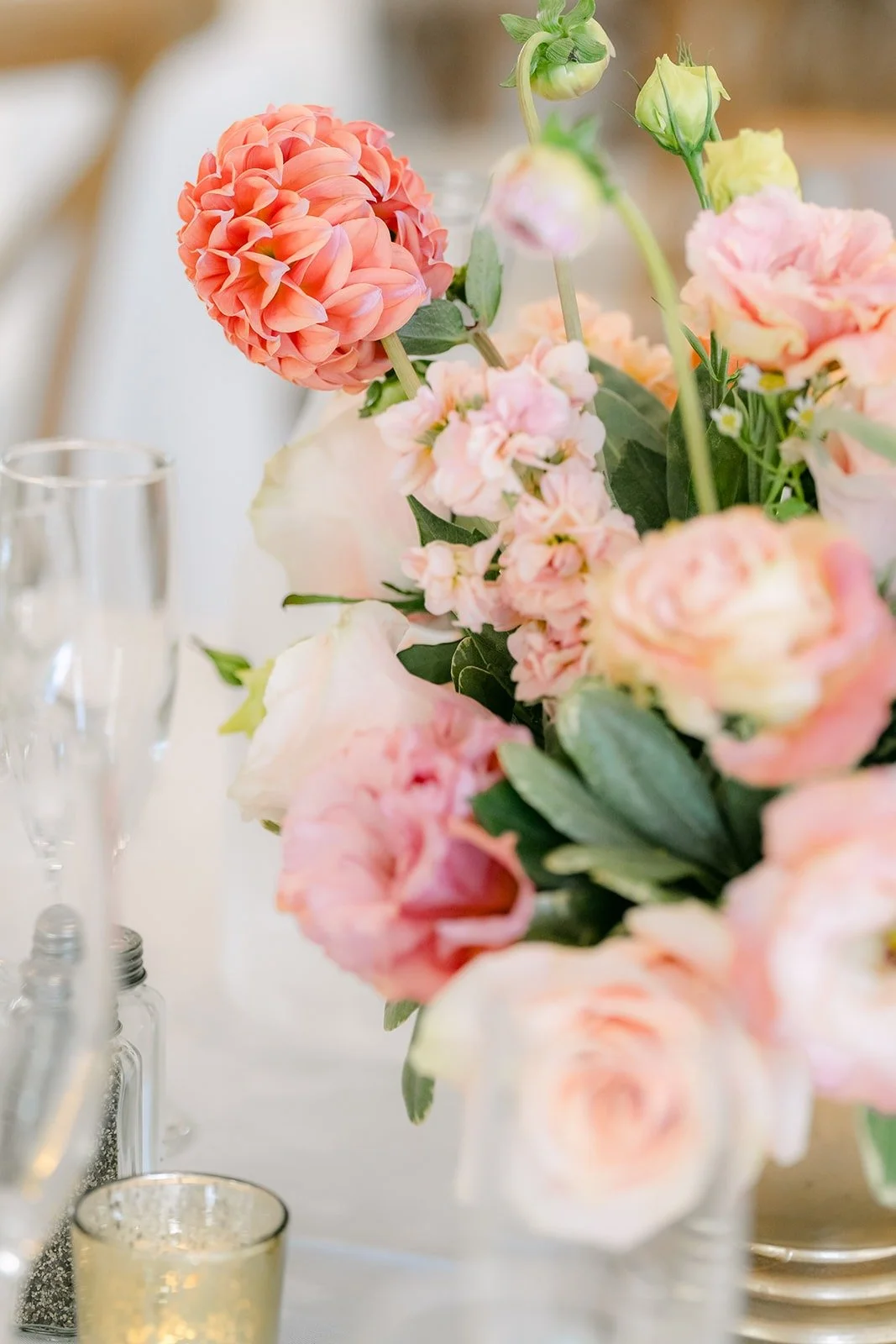 A close view of pink and peach blooms on a reception table