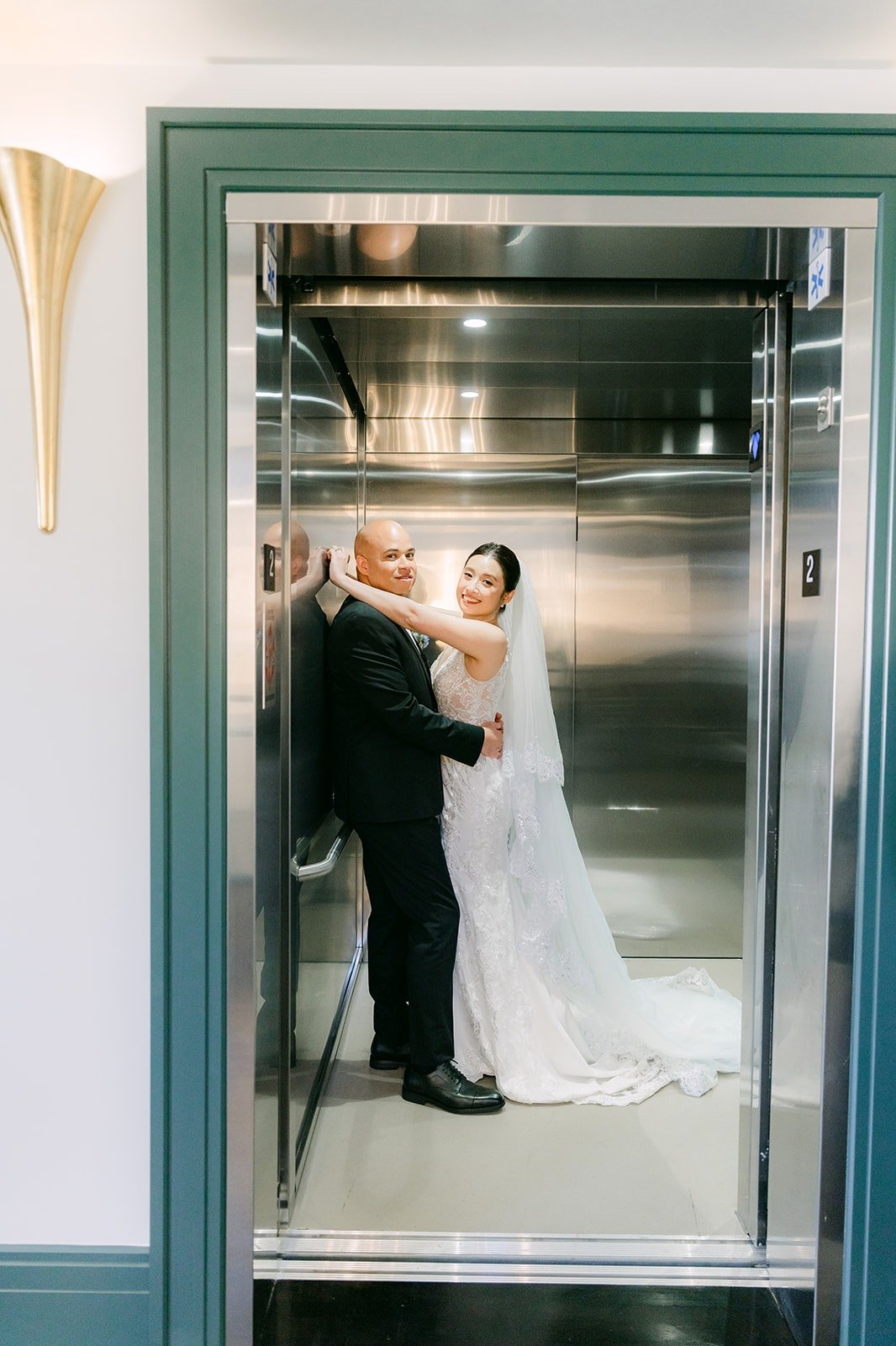 Elisa and Brandon embrace inside the vintage elevator