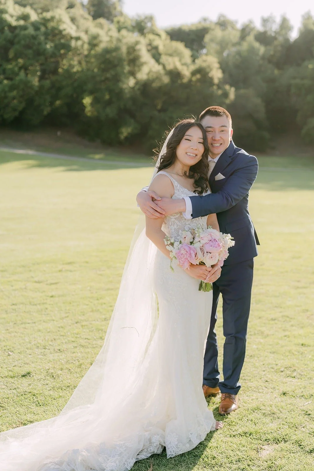Kelli and Alex hugging on the open golf course lawn at Los Robles Greens