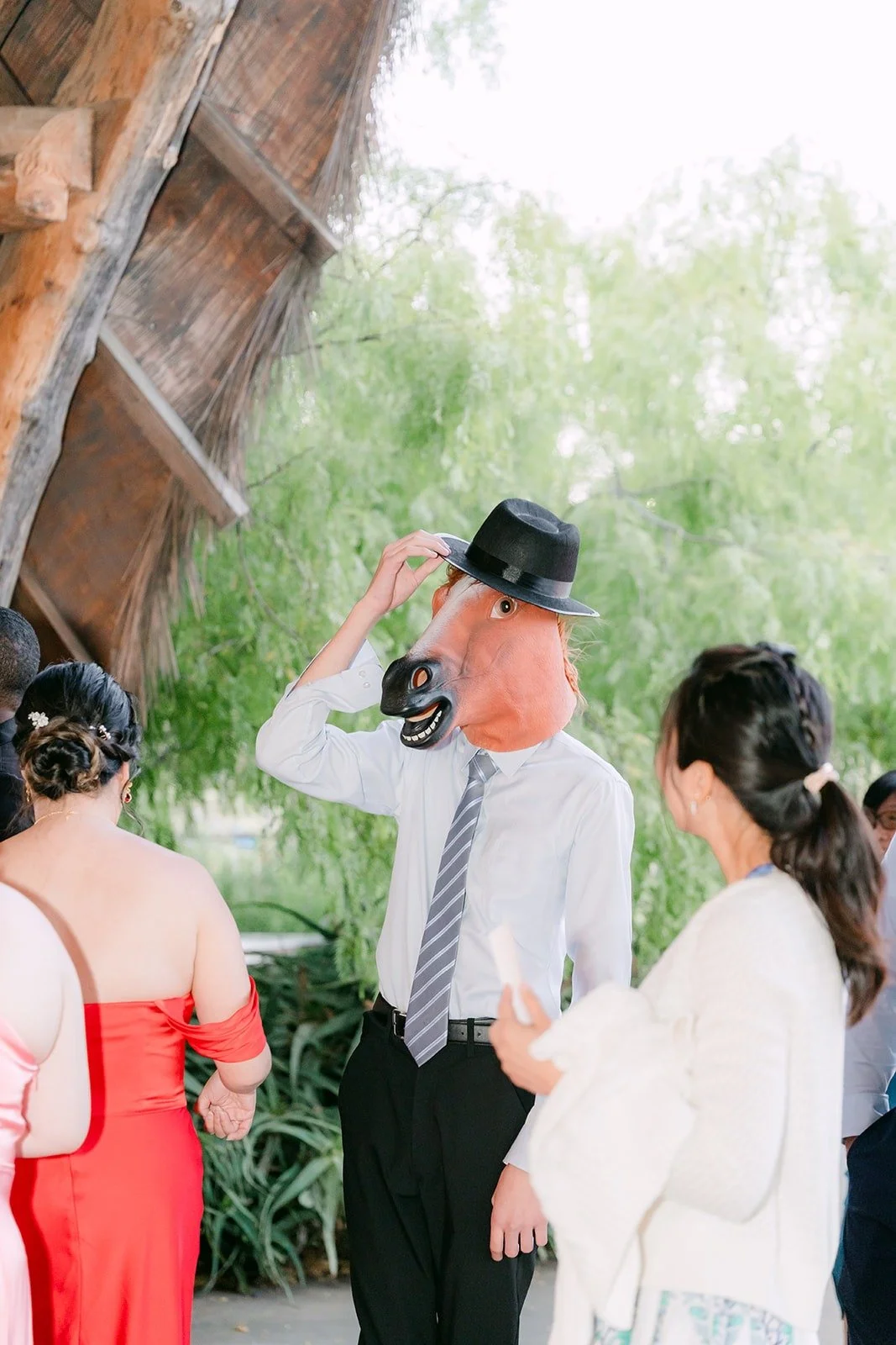A guest wearing a top hat and mask at the photo booth