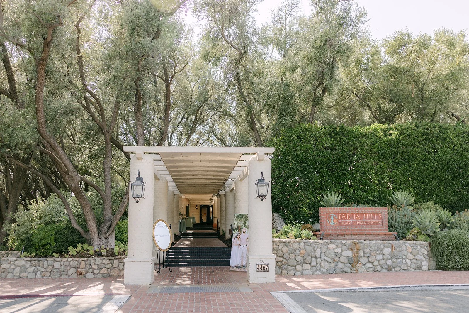 Covered entry walkway at Padua Hills Theatre framed by olive trees