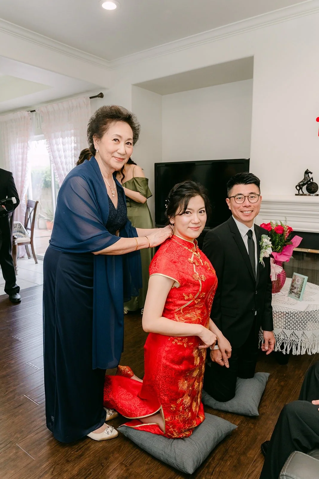 Eunice kneels during the tea ceremony as a family member looks on