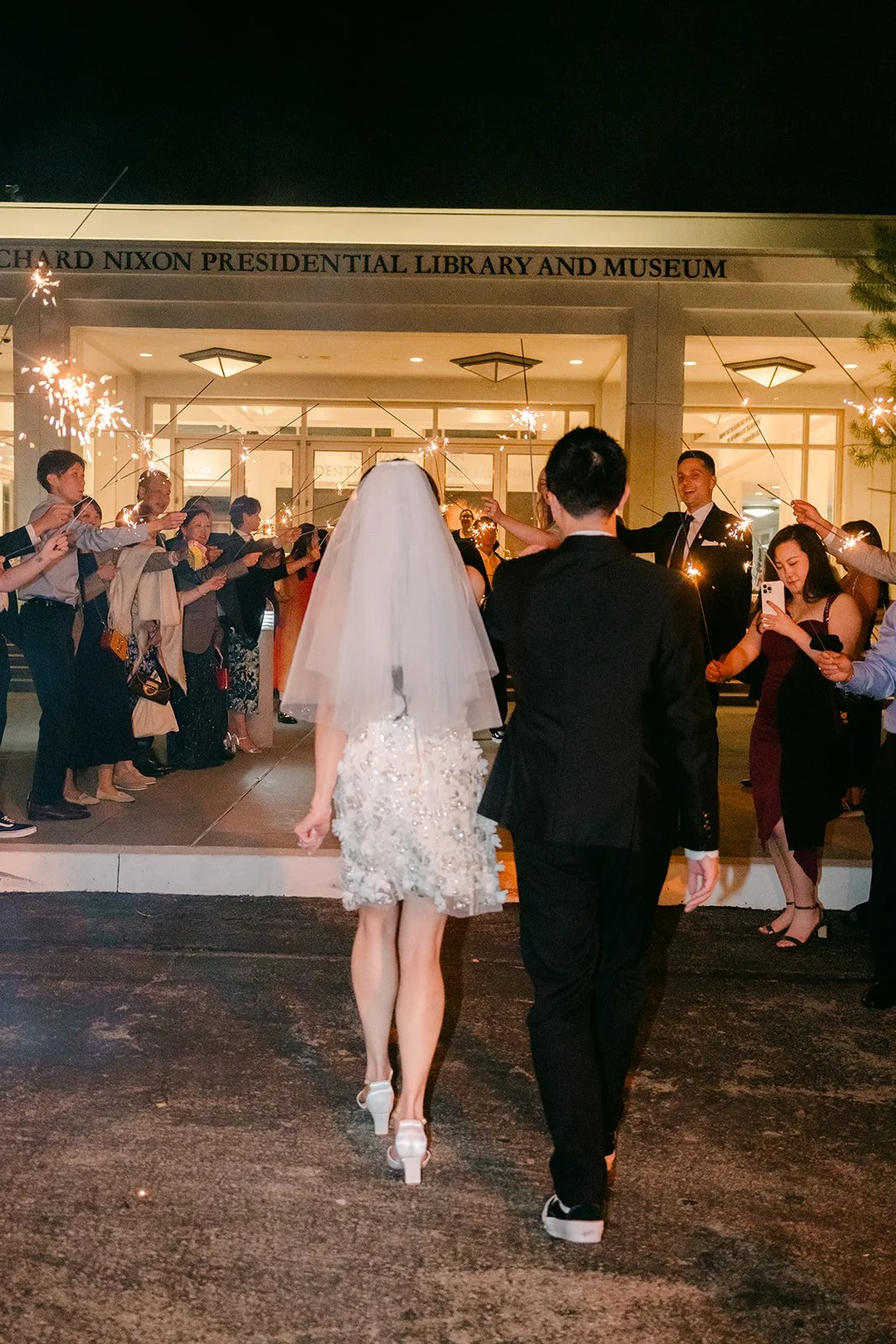 Jenny and Ryan walking away hand in hand at night.