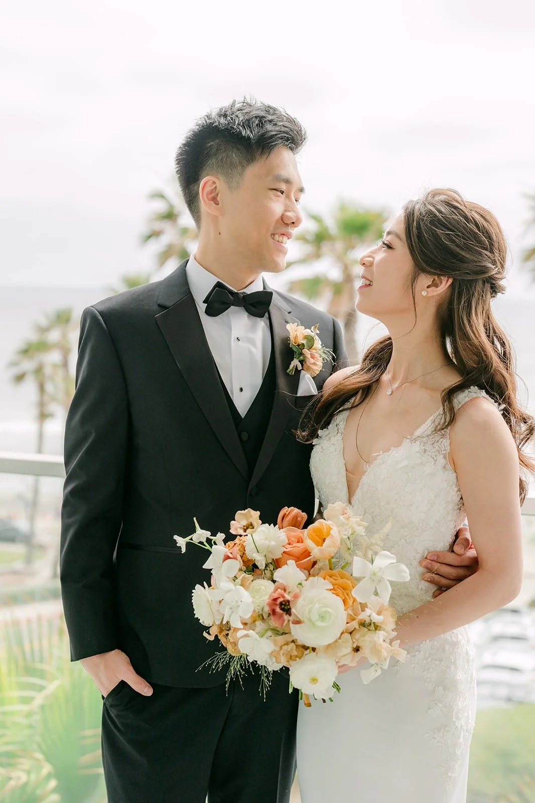 Angela and Eli smiling together with her bouquet after the first look, photographed by One and Only Production
