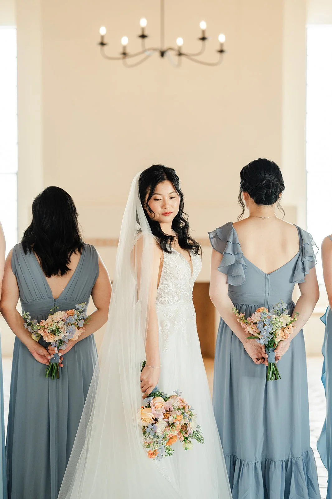 Constance with her bridesmaids under a chandelier