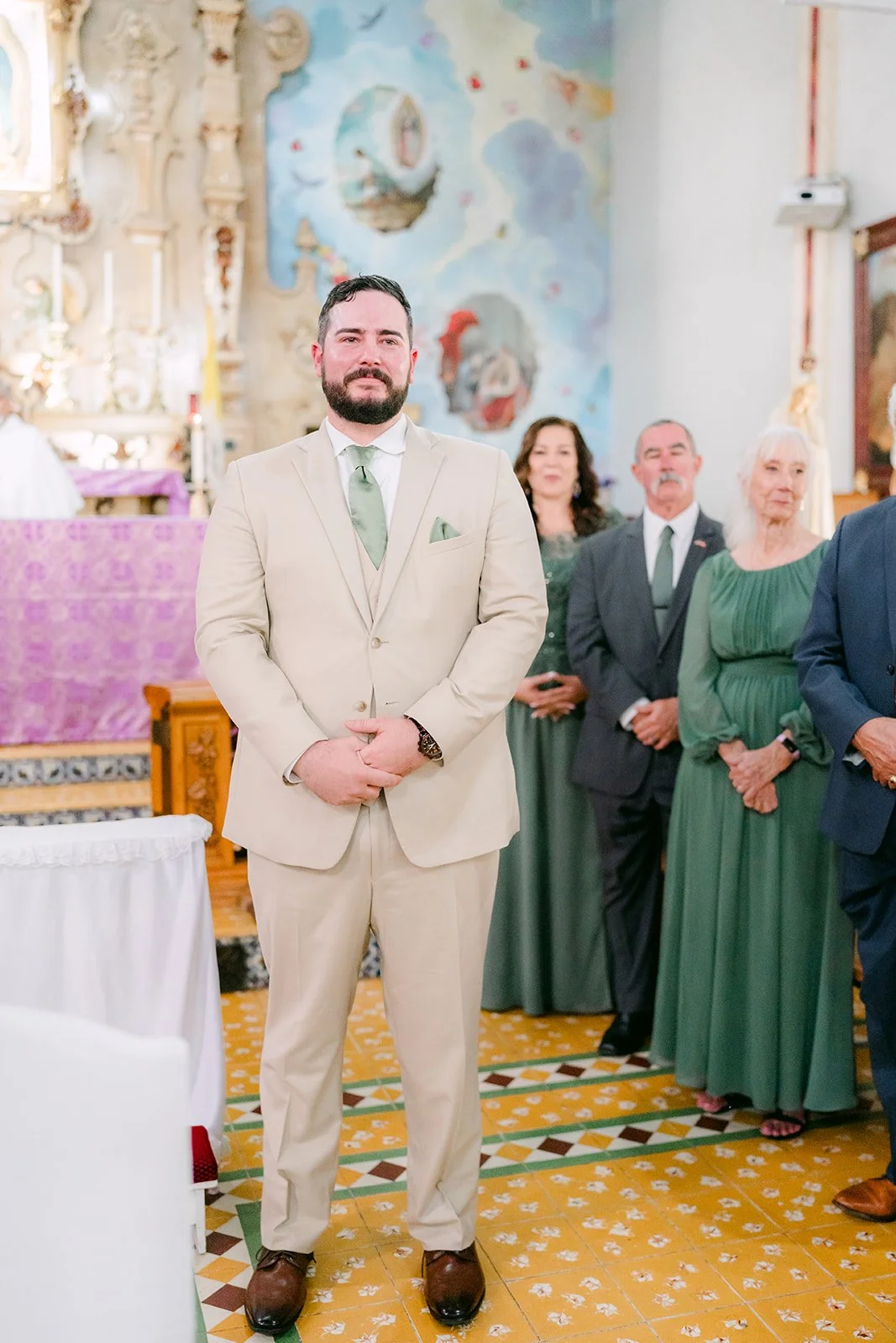 Cody waiting at the altar in his tan suit.