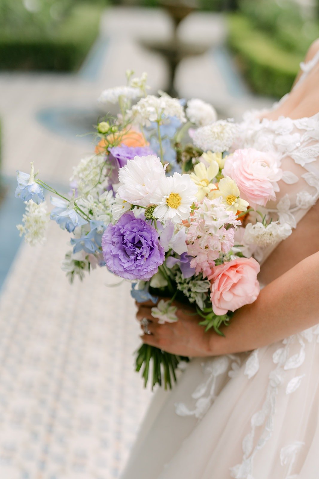 Kylie's bouquet of lavender, peach and white blooms held at her waist