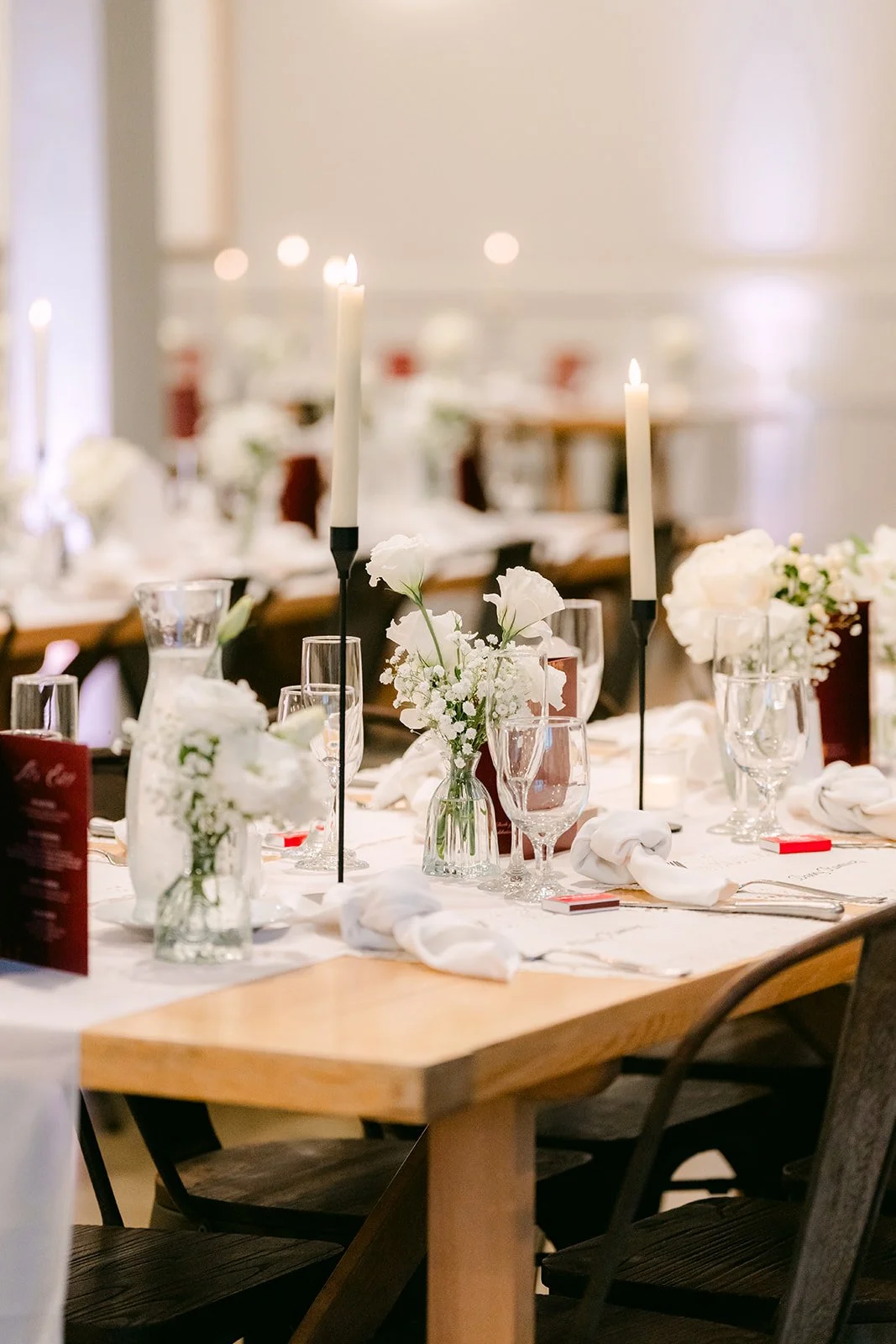 Long table set with candles and burgundy menus