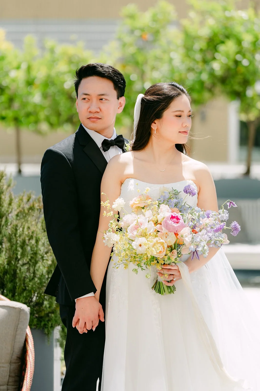 Groom holding the bride's hand on the hotel's garden terrace