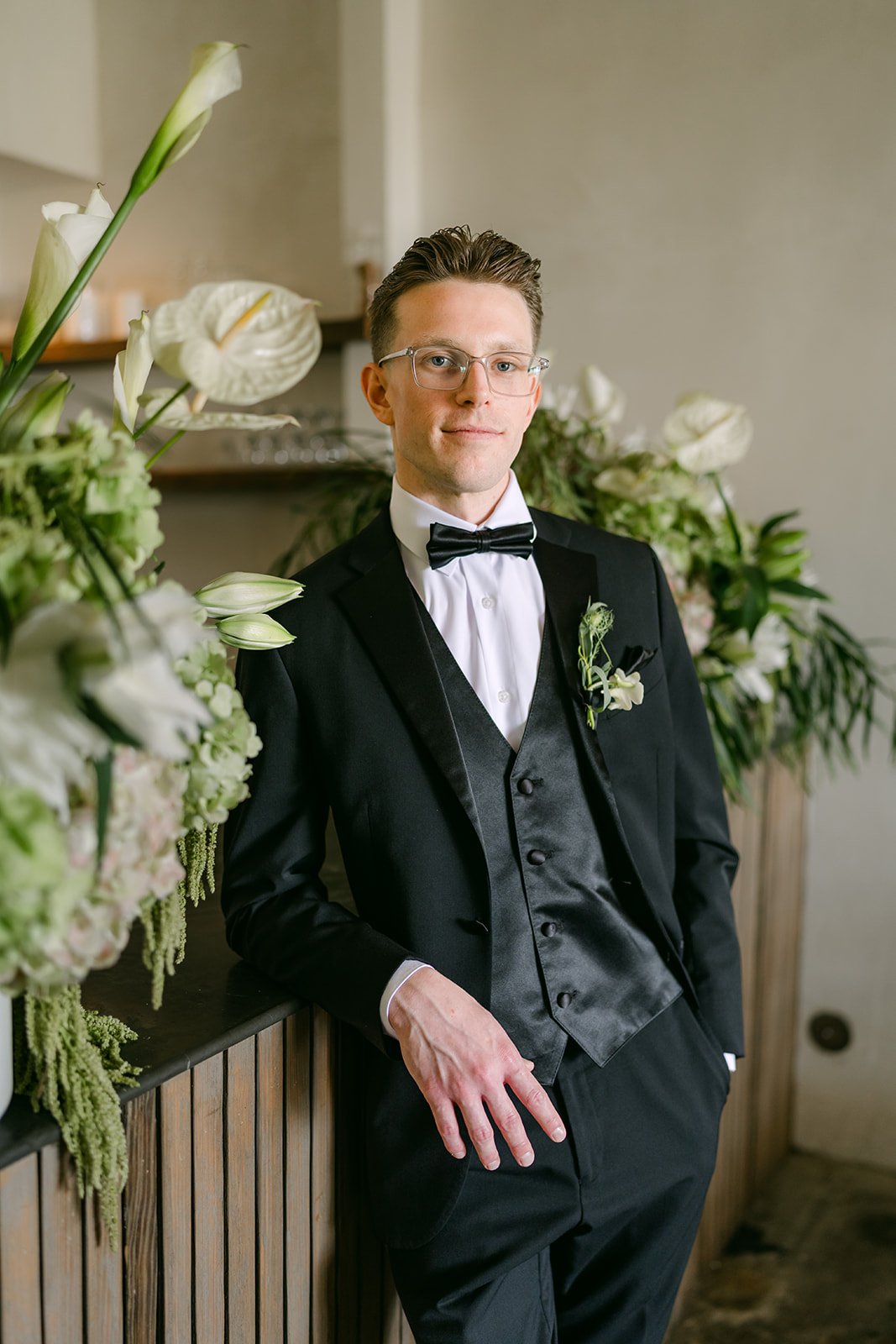 Matthew smiling by the white florals