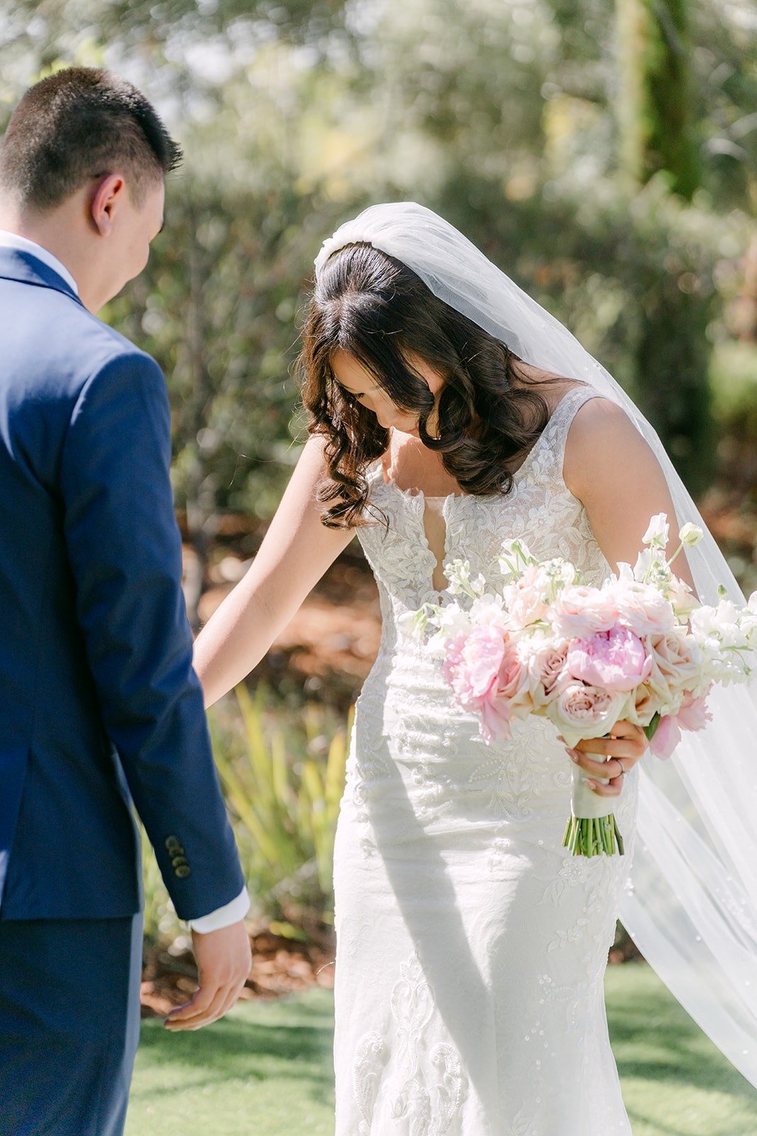 Kelli smiling and looking down at her gown as Alex turns around