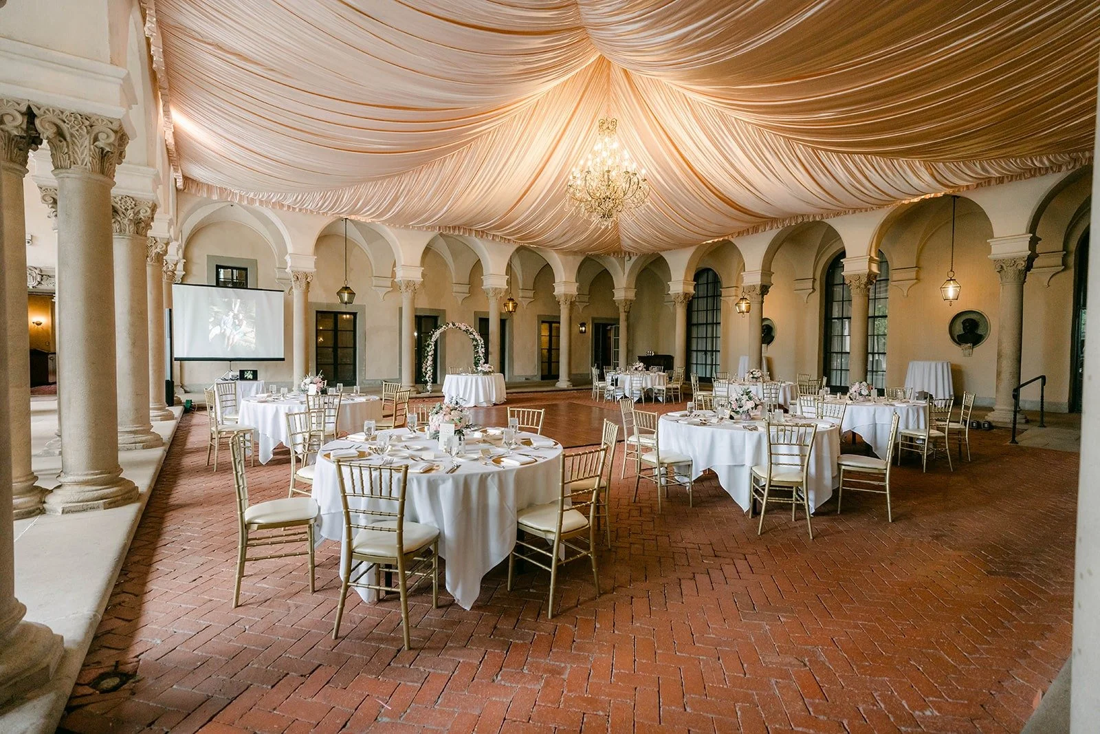 The West Patio reception under draped fabric and chandeliers