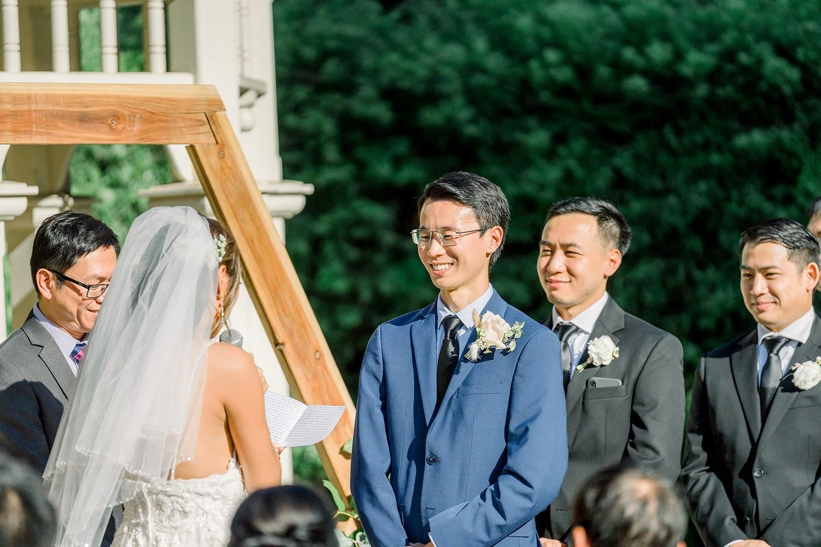 The groomsmen smiling during the vows