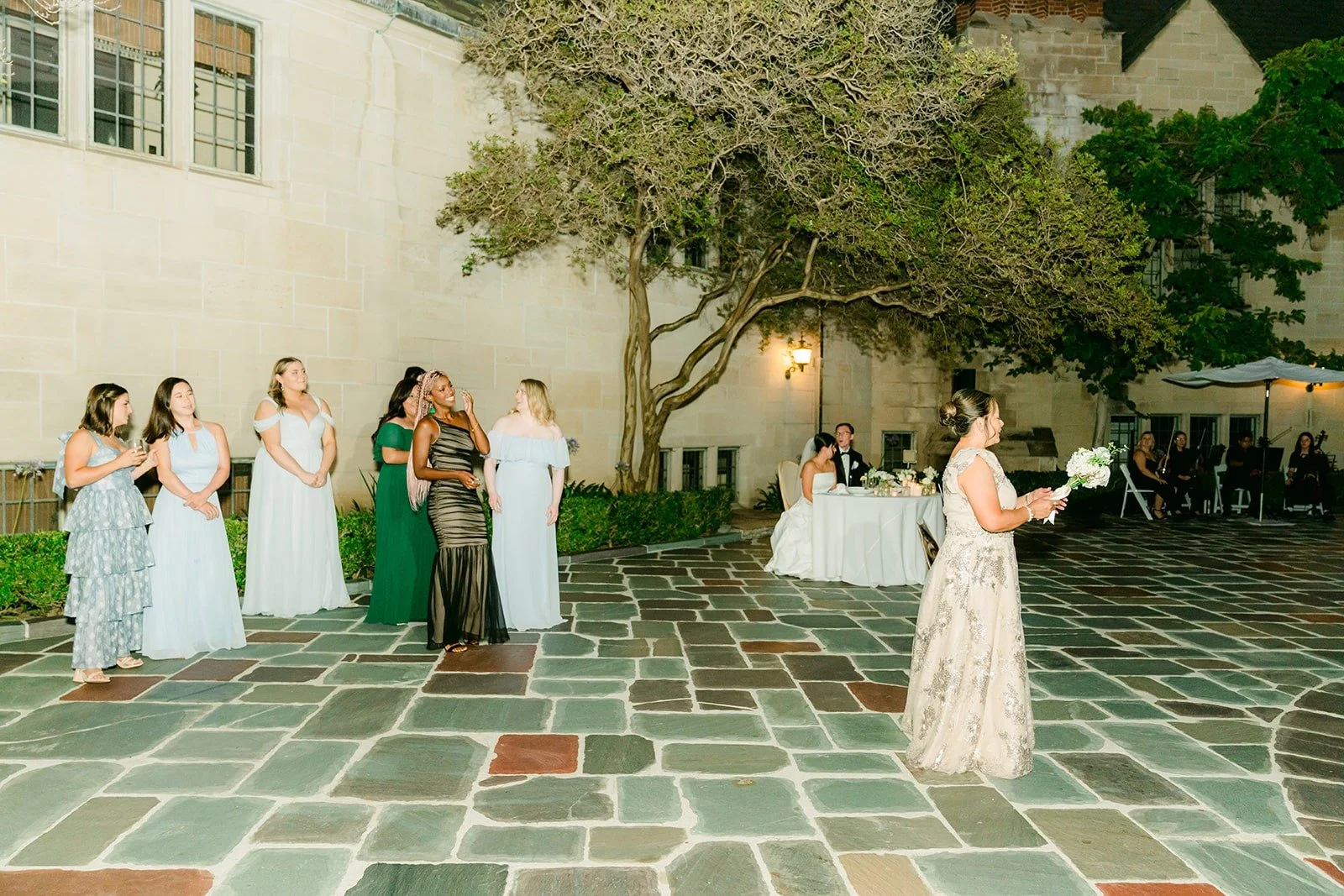 Guests gathering in the courtyard for the bouquet toss