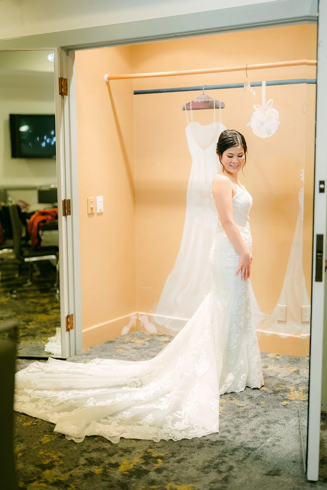 Xuemin in her gown with the long train spread out in the bridal suite