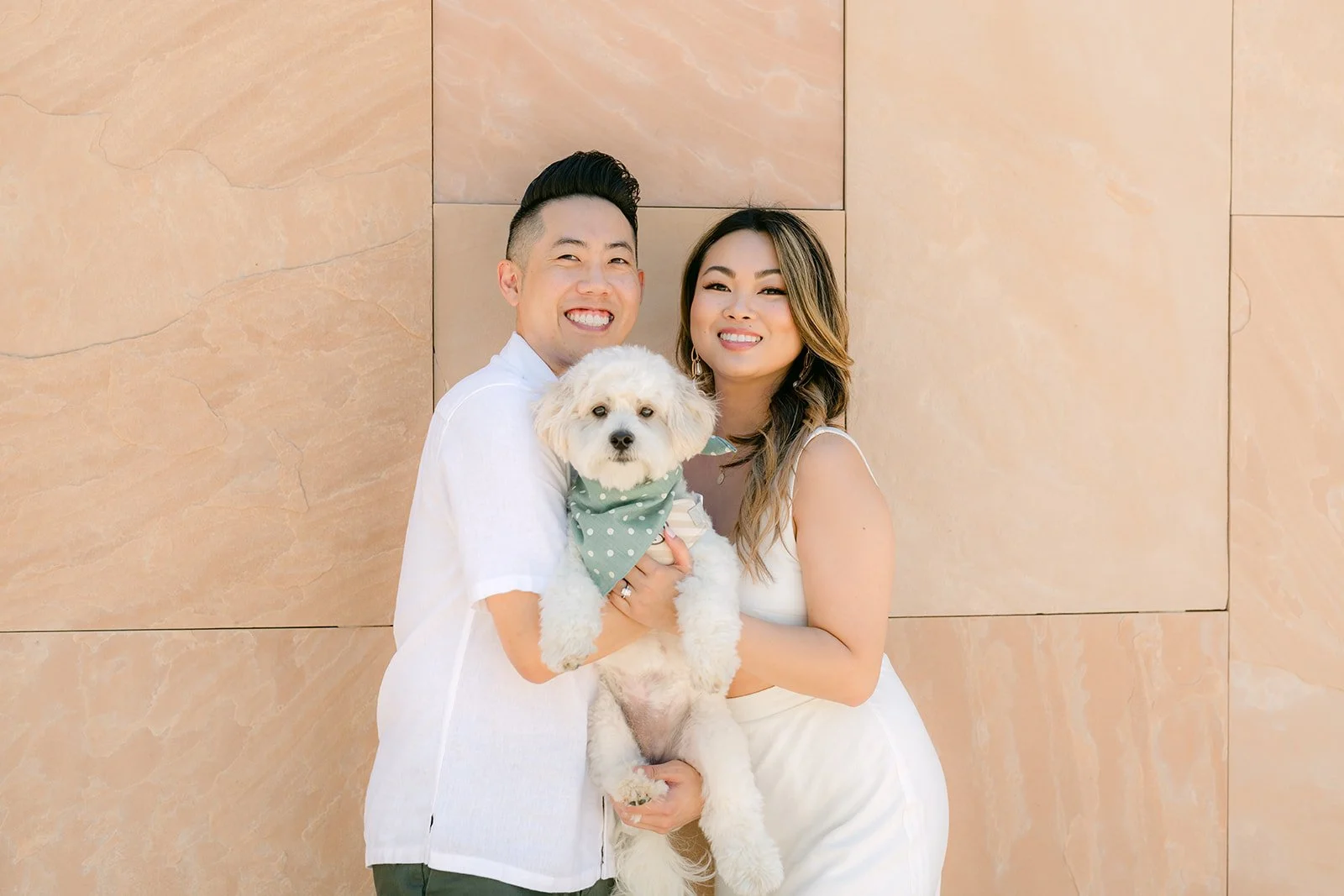 Stephanie, Alan and Tofu against the warm sandstone wall.