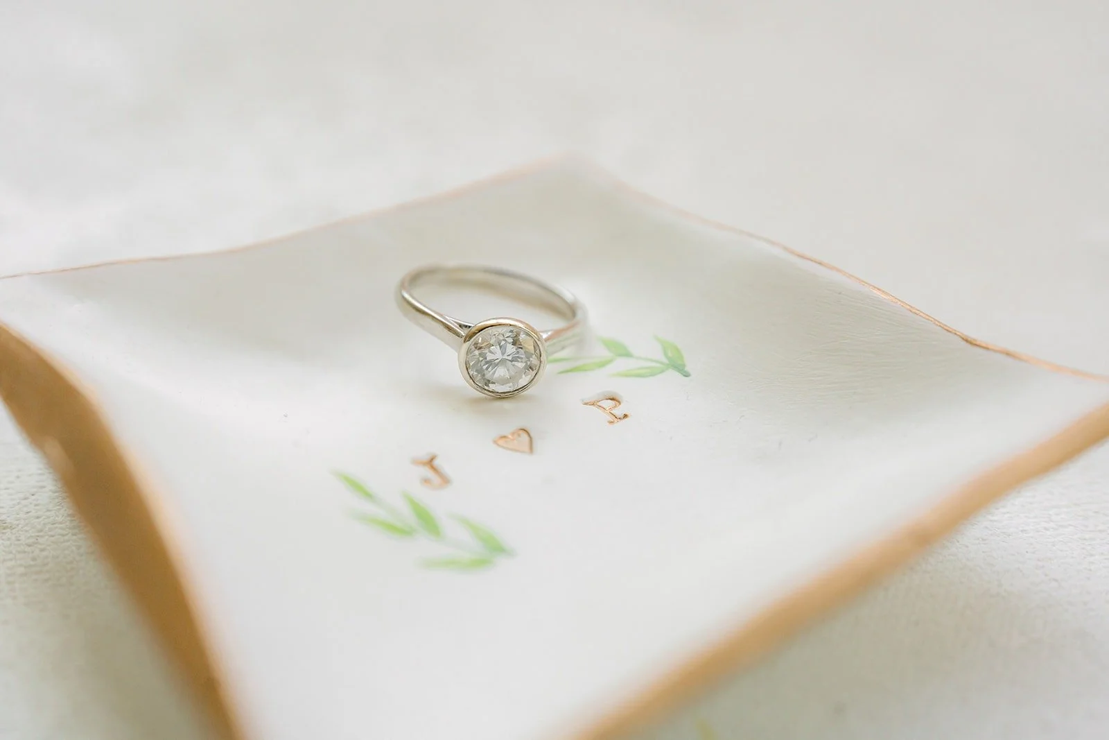 Jessie's engagement ring resting on a white porcelain dish