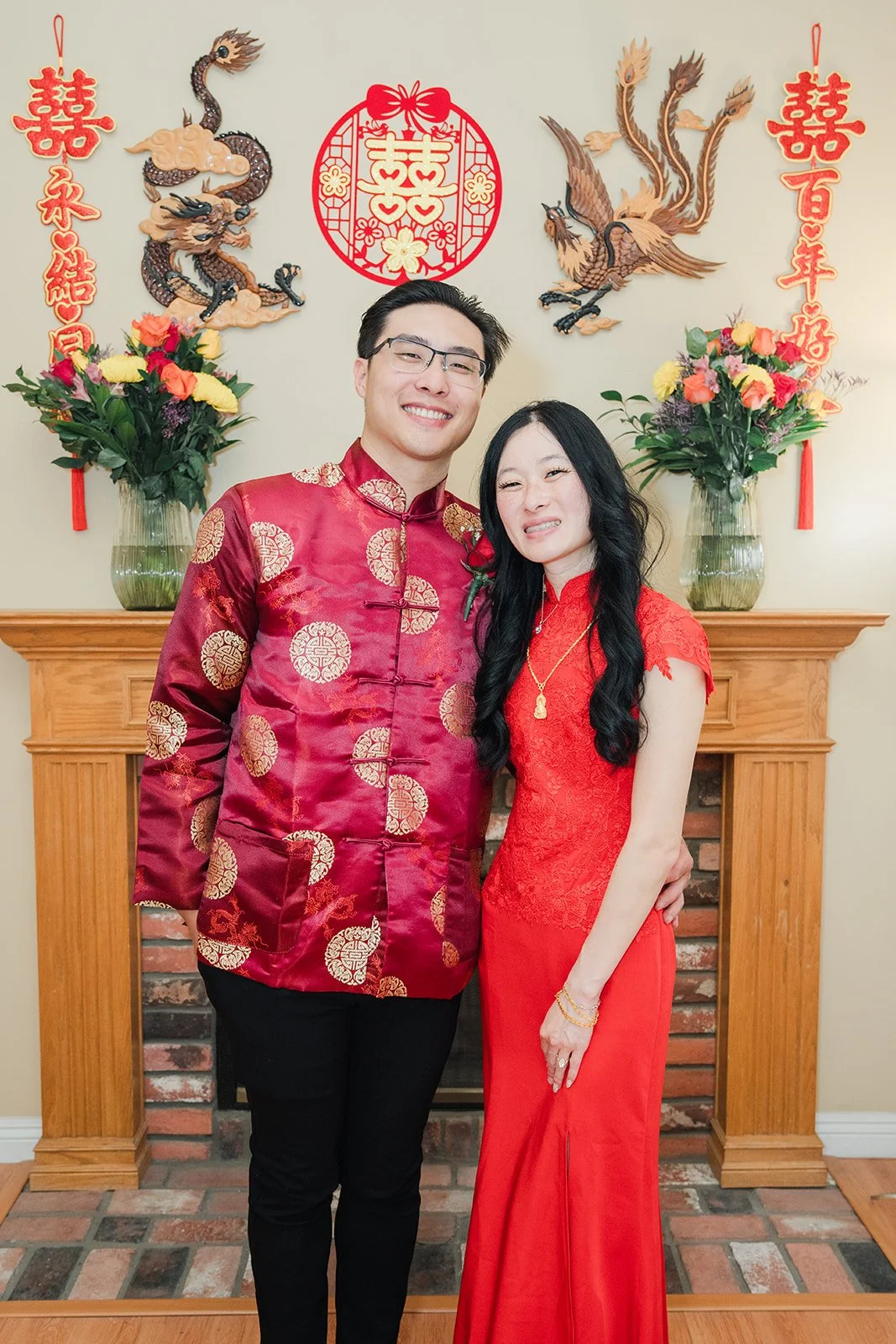 Valerie and Danny in front of the dragon and phoenix mantel.