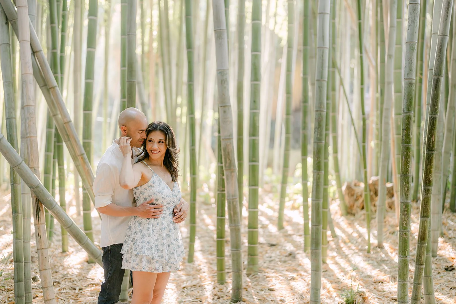 Francesca and Daniel lean in close among the bamboo.