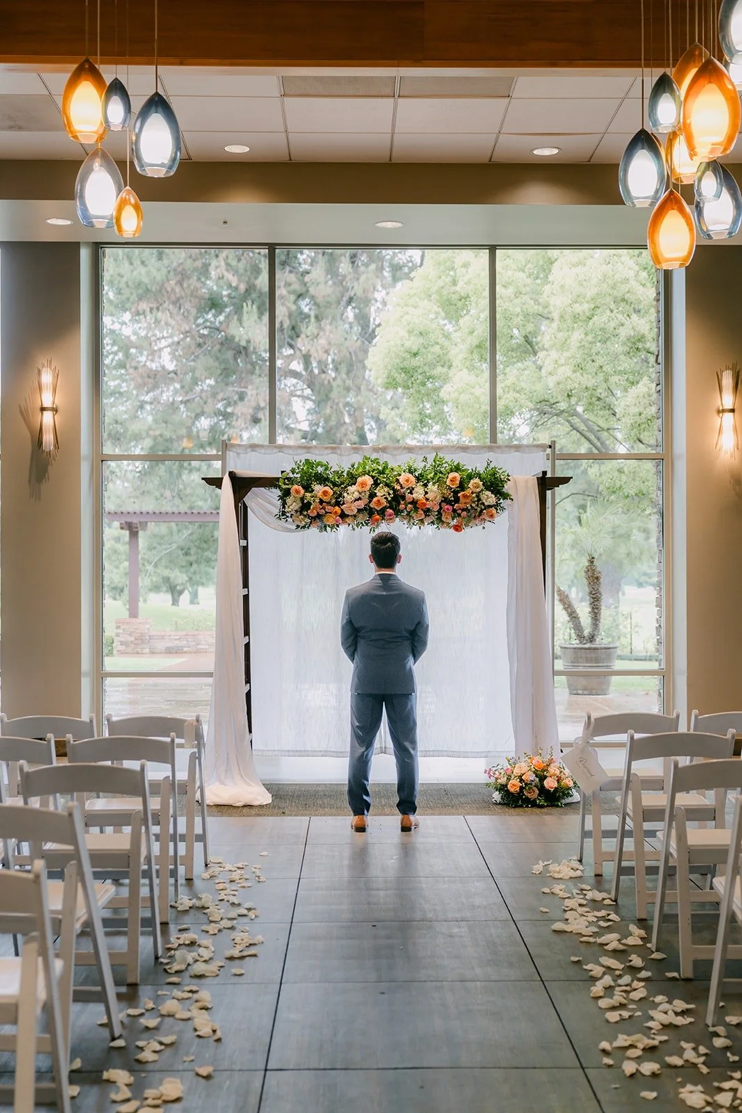 Mark waiting with his back turned at the floral arch before the first look at Rio Hondo
