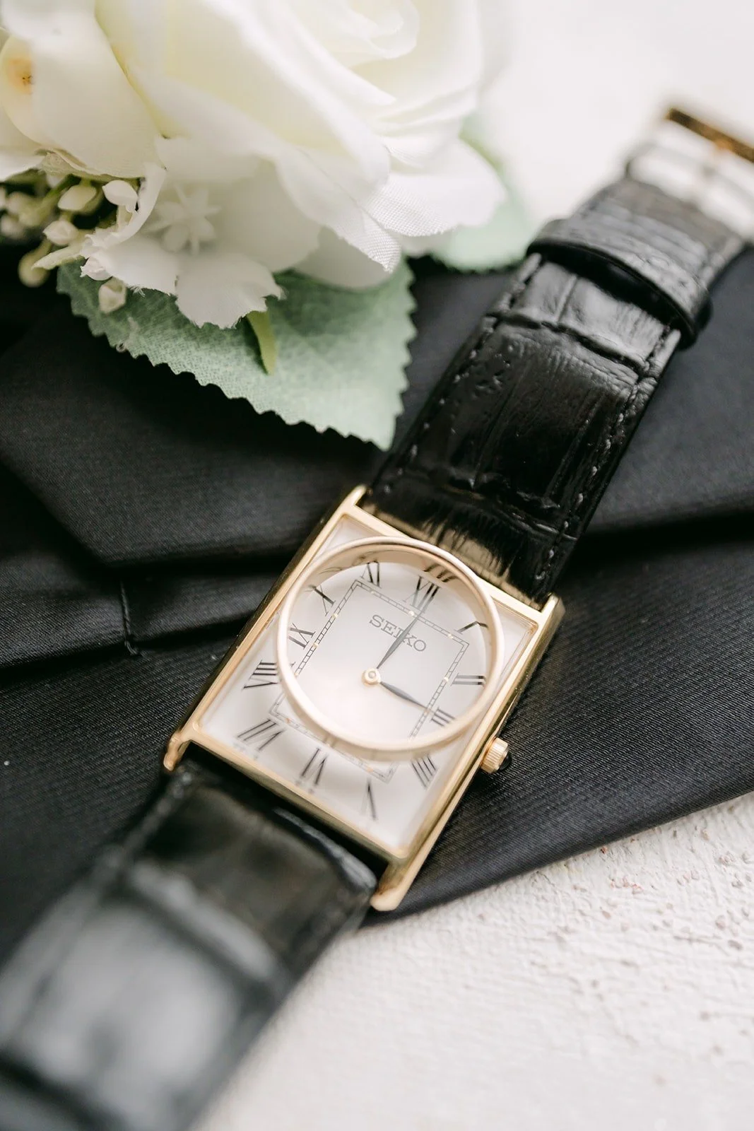 Close up of Yao's gold watch on a black tie
