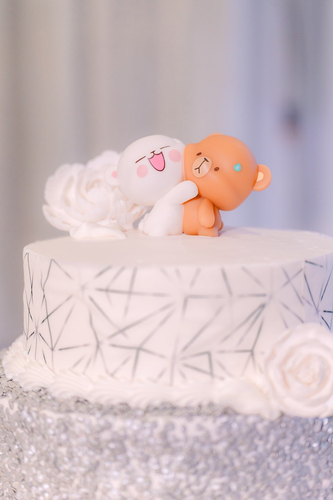 Plush bear cake toppers on the white wedding cake