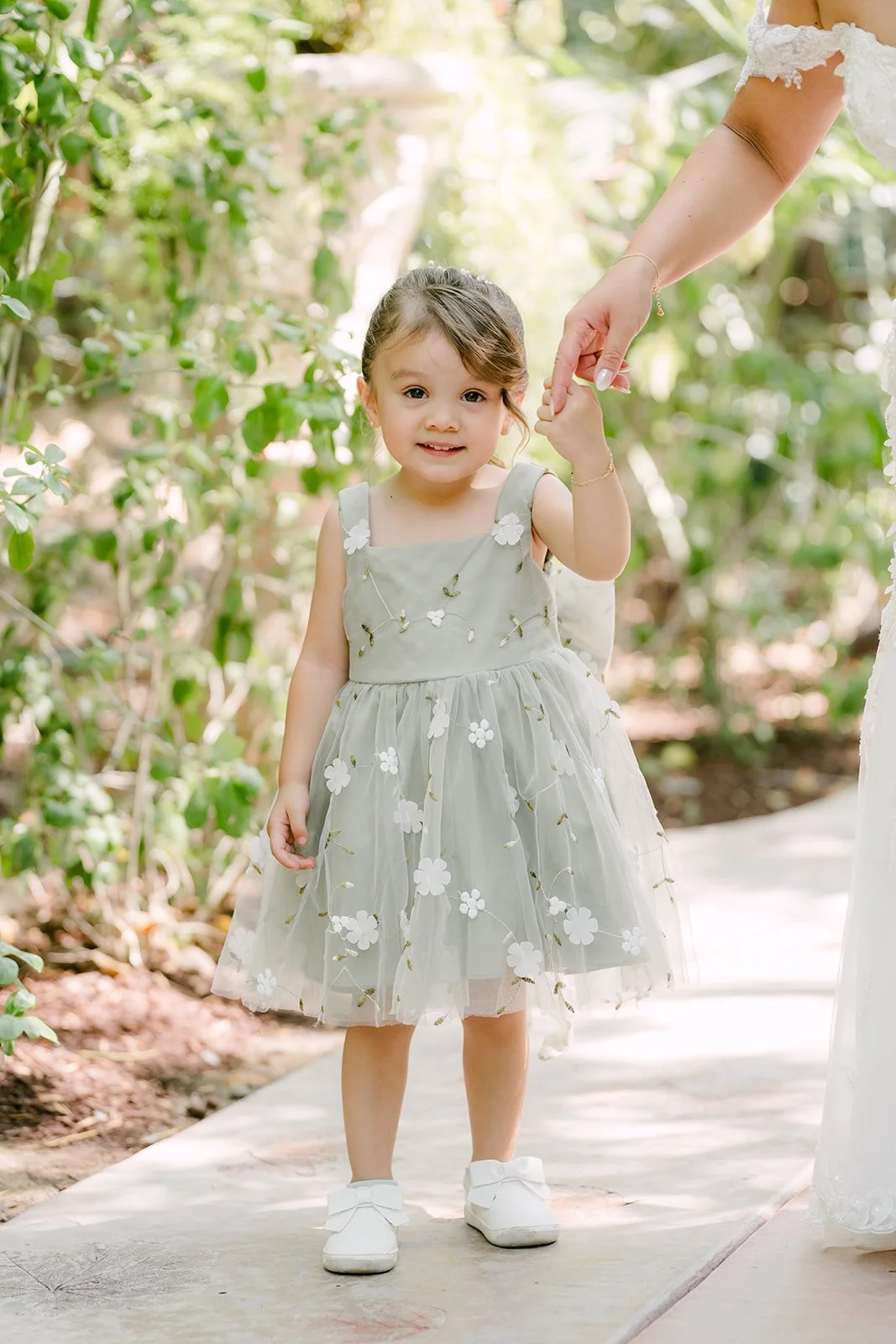 Flower girl Auri in a sage green tulle dress.