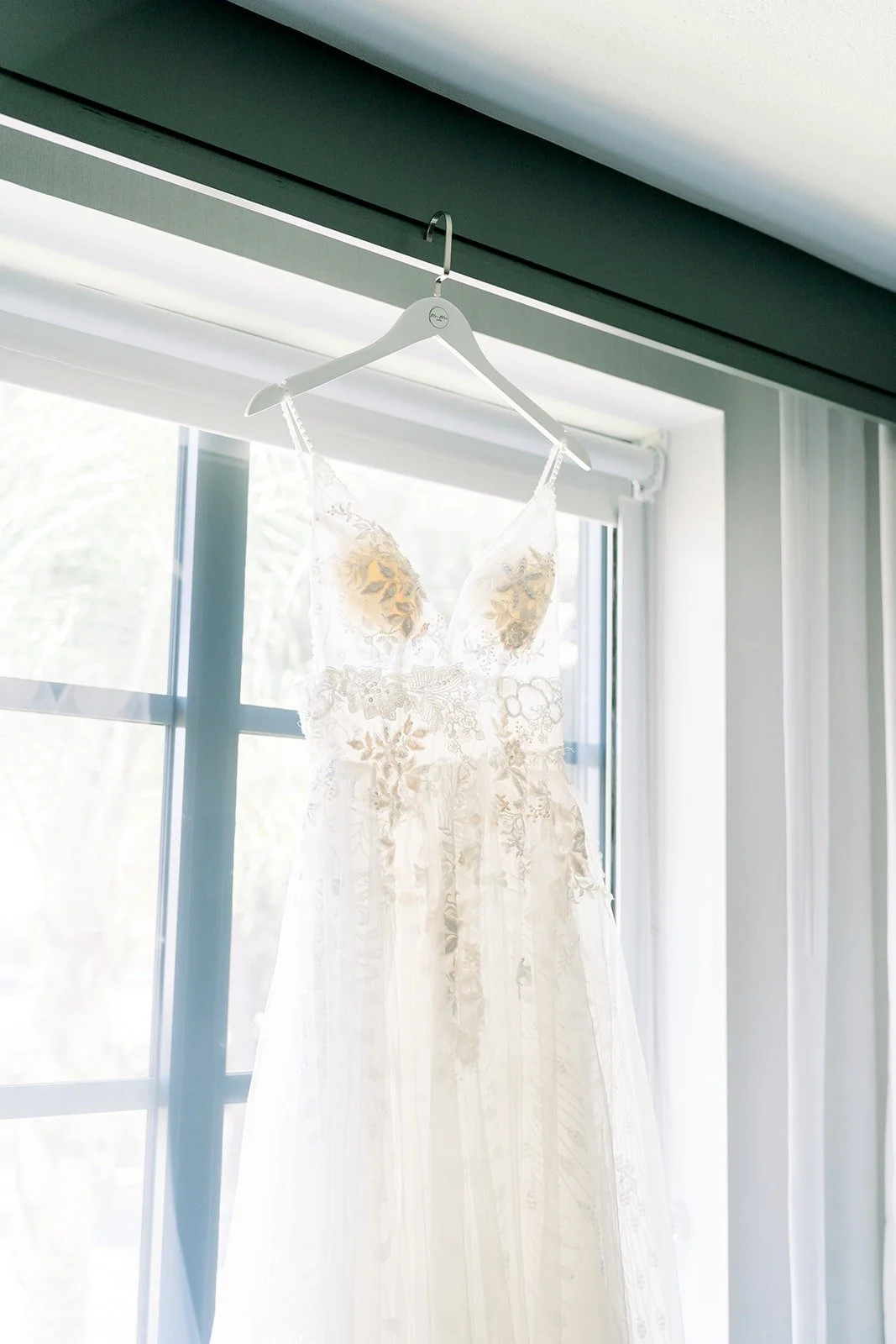 Ariel's wedding gown hanging in the window at Camarillo Ranch House