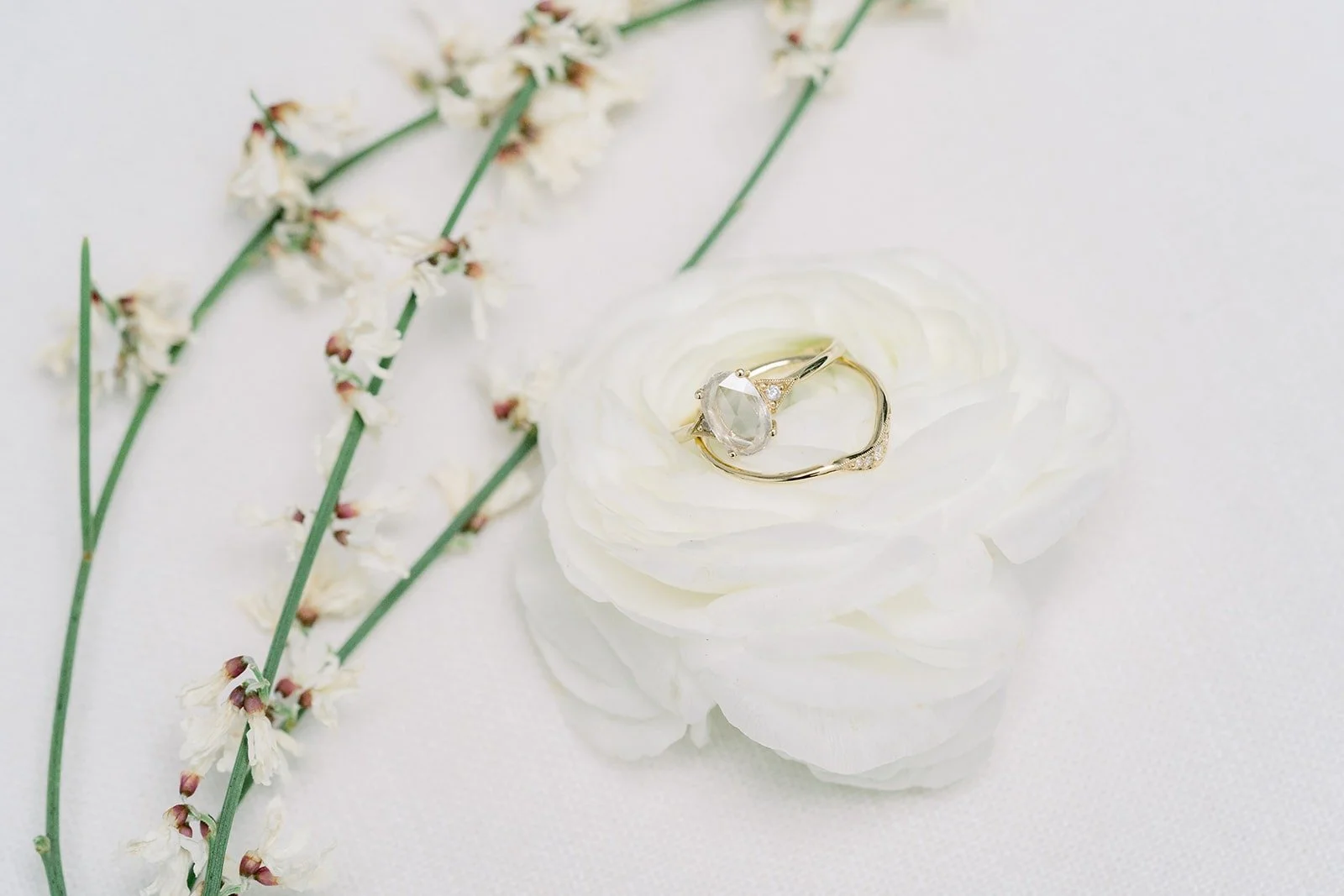 A wedding band on a white flower with blossom branches