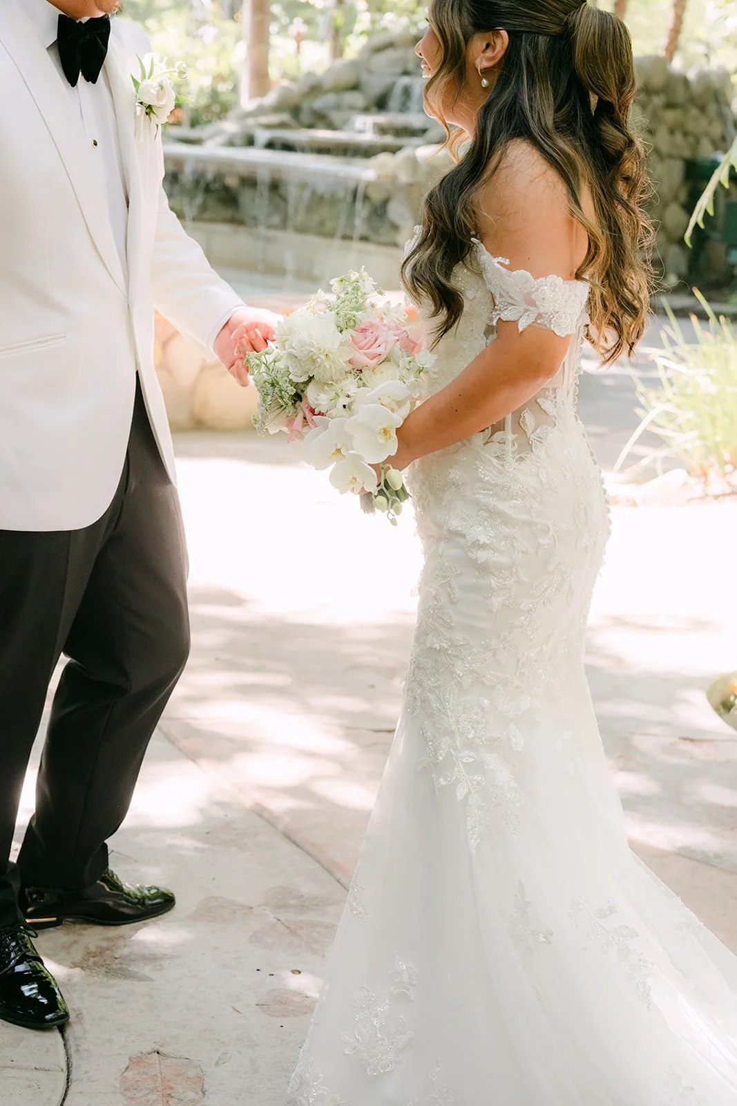 Nicole's off the shoulder lace gown as she faces Caryl at their first look.