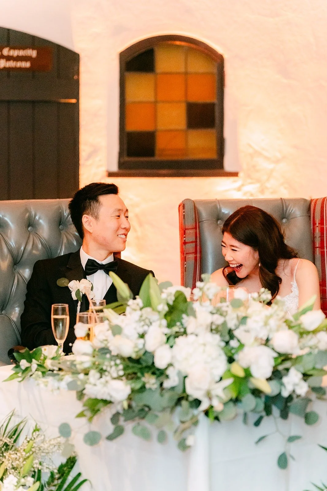 Valerie and Jason listening to speeches from the sweetheart table