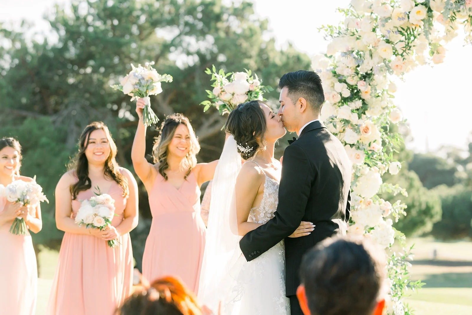 Bridesmaids watching the vows with their bouquets