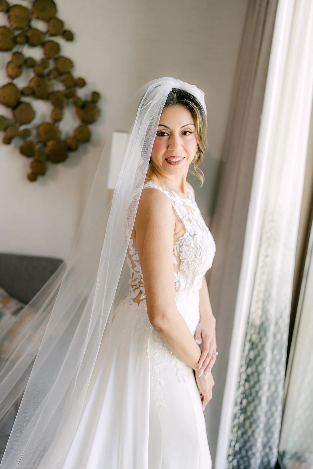 Francesca in her cathedral veil by the window of the Bride Suite at The Westin Anaheim Resort