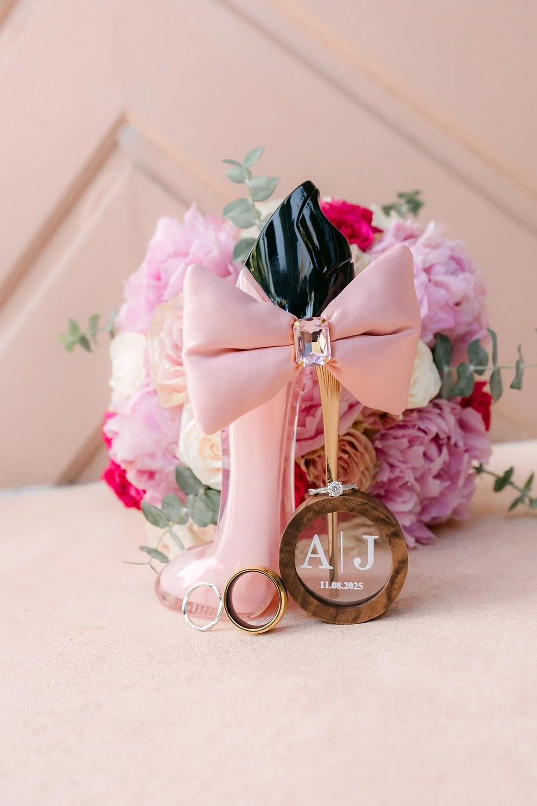 Perfume bottle and wooden ring box tied with a pink bow and flowers