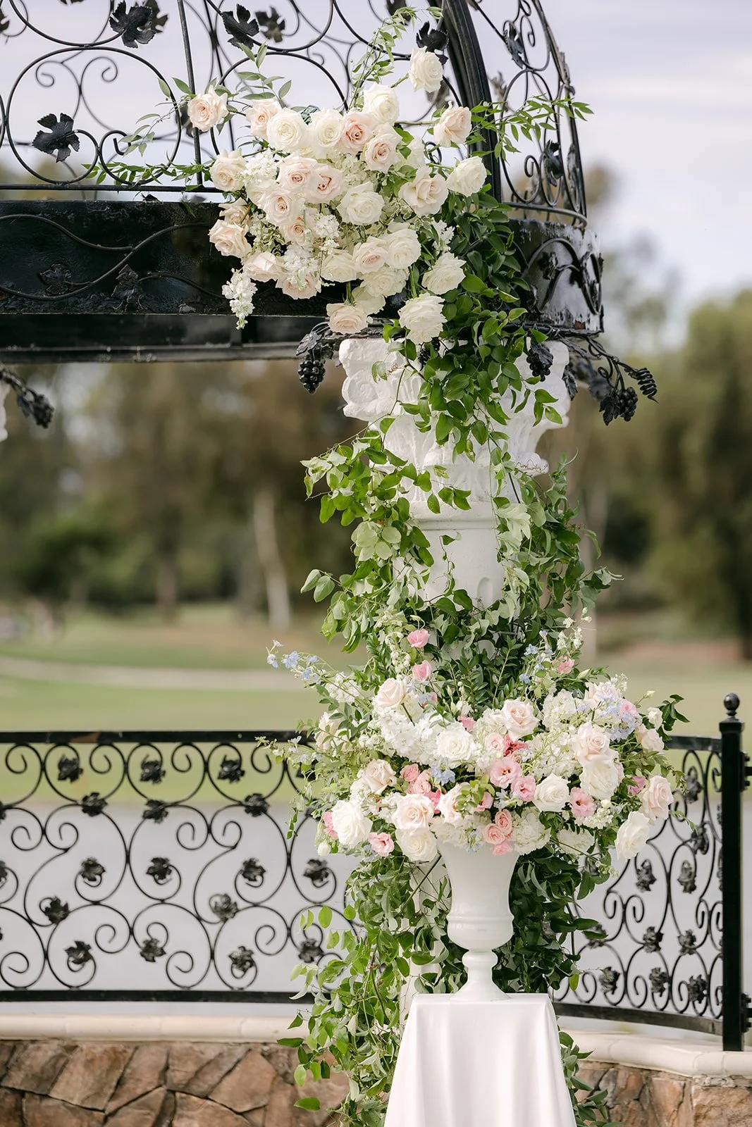 White florals and greenery wrapped around the gazebo