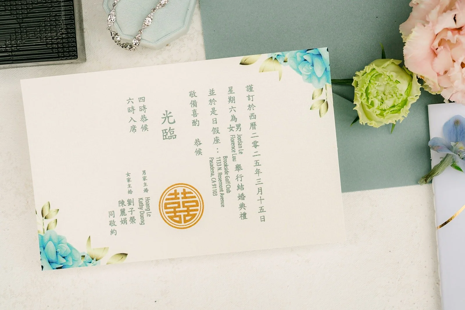 Invitation and gold seal styled with blush and blue blooms