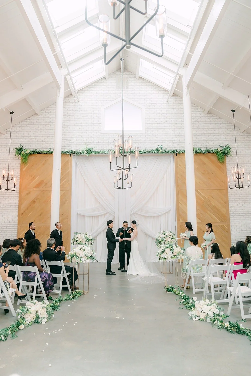 A wide view of the ceremony under the skylights