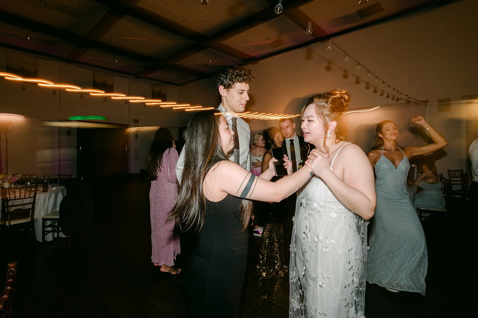 Friends dancing together under the purple lights