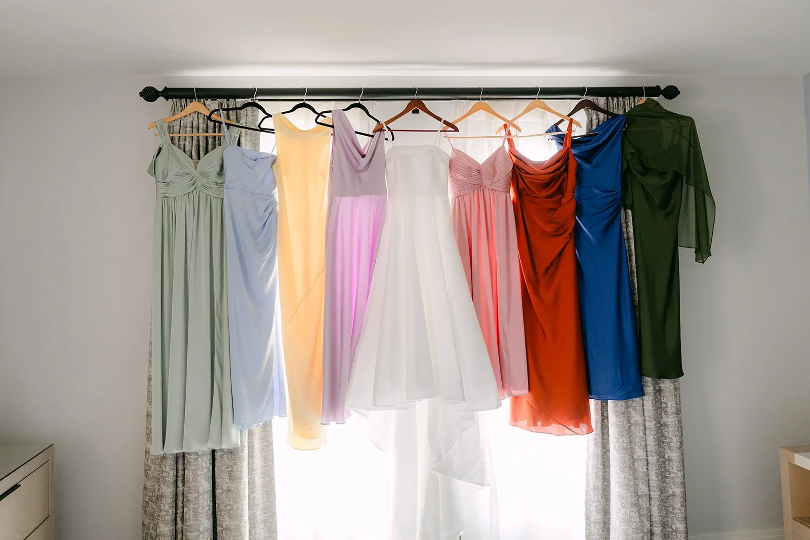 The full rainbow of bridesmaid dresses in the window