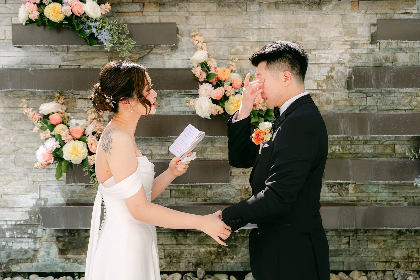 Amanda and San holding hands during their private vows at Courtyard Monterey Park, photographed by One and Only Production.