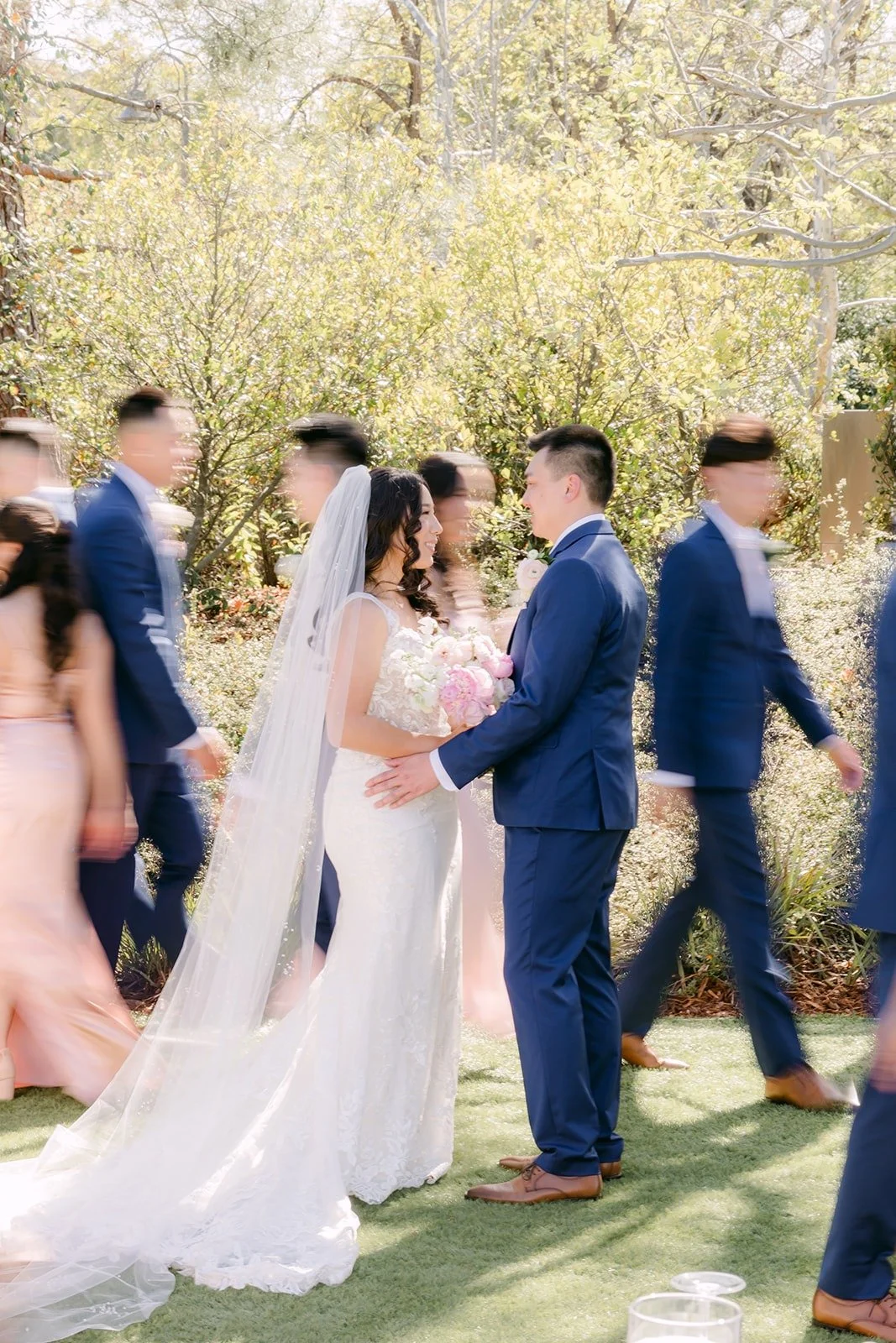 Kelli and Alex walking with the wedding party across the lawn