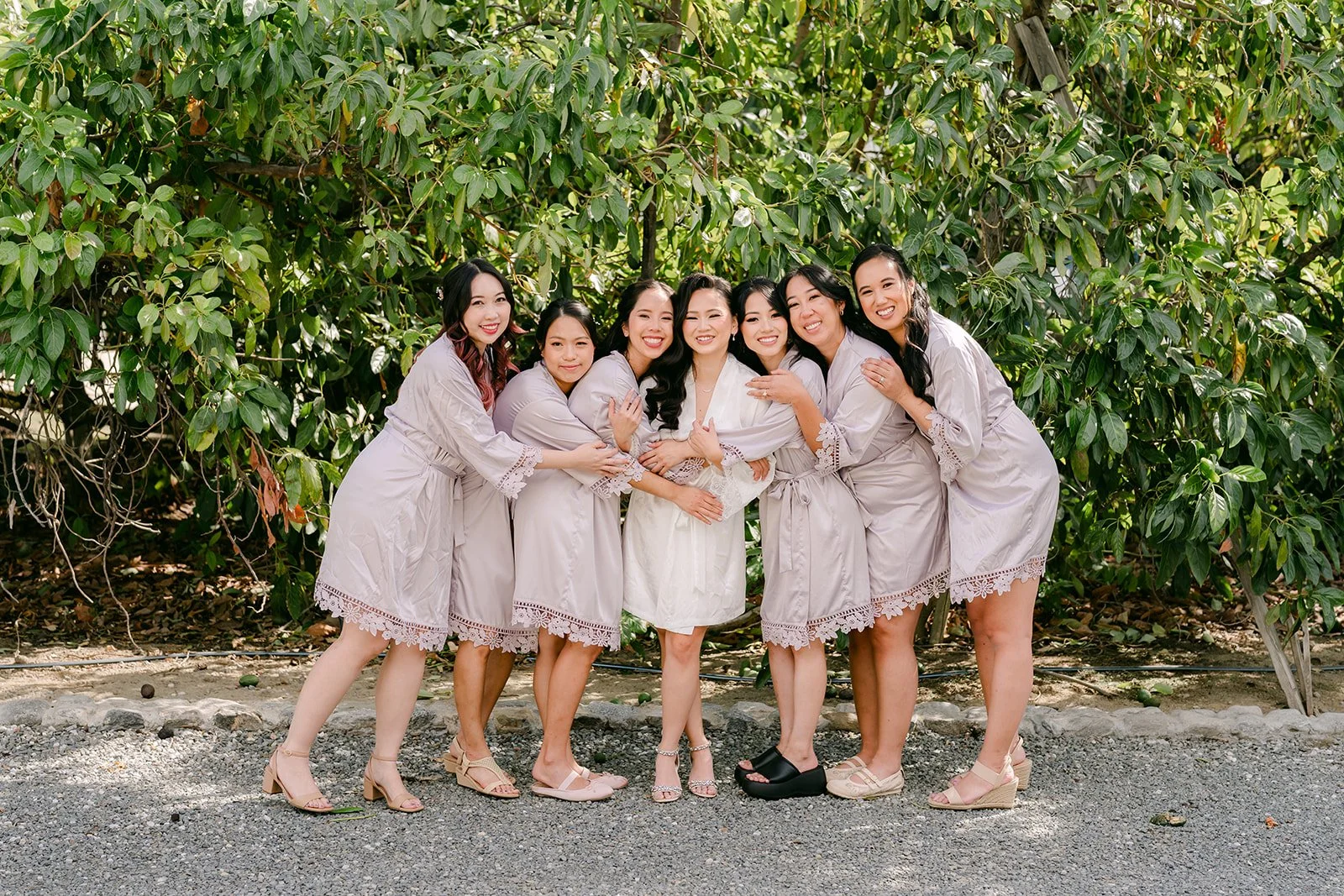 Vannie and her bridesmaids posing in their robes outside.