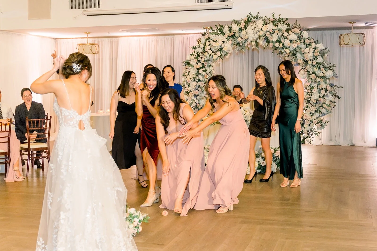 Friends reaching for the bouquet
